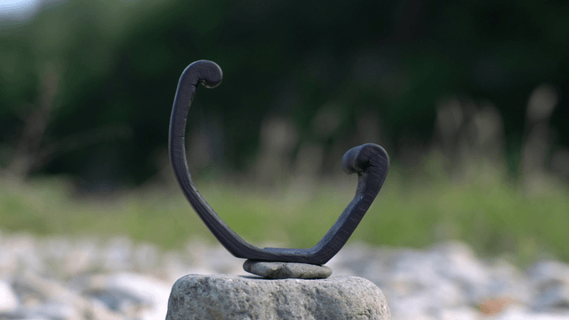 Curved wooden sculpture placed on stone