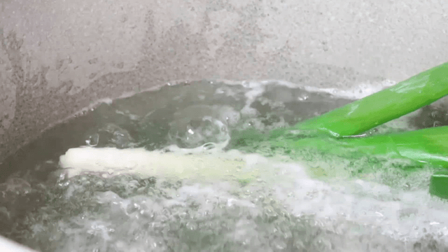 Onion added to boiling water with green onions