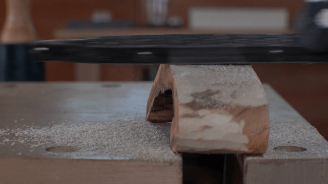 Woodcraft artisan filing wood on workbench