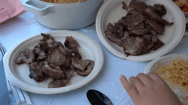 Grilled meat and ramen on a table