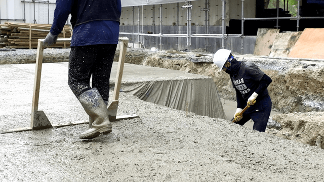 Construction workers leveling wet concrete