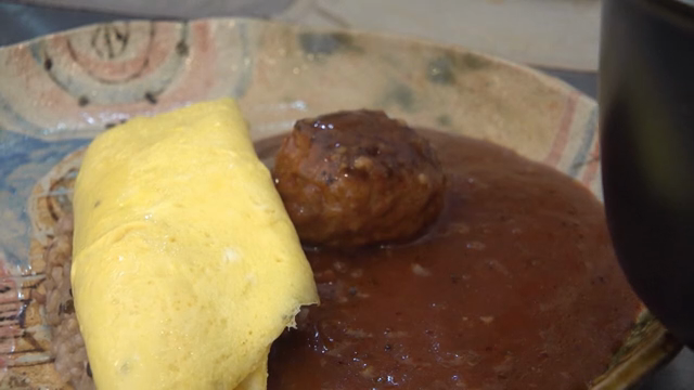 Omelette rice with sauce being served