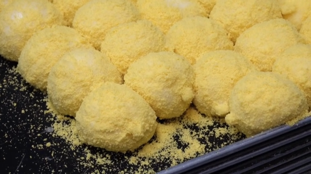 Yellow rice cake being prepared on a tray