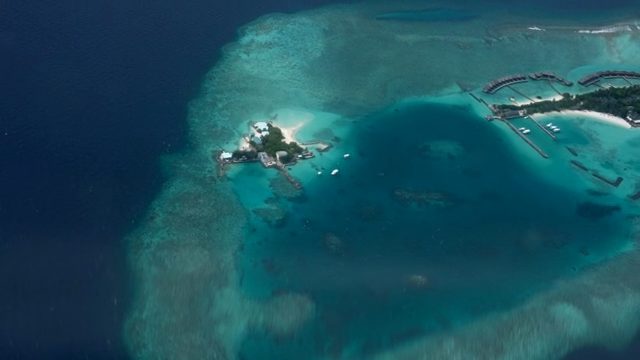 Tropical island with clear blue sea as seen from an airplane