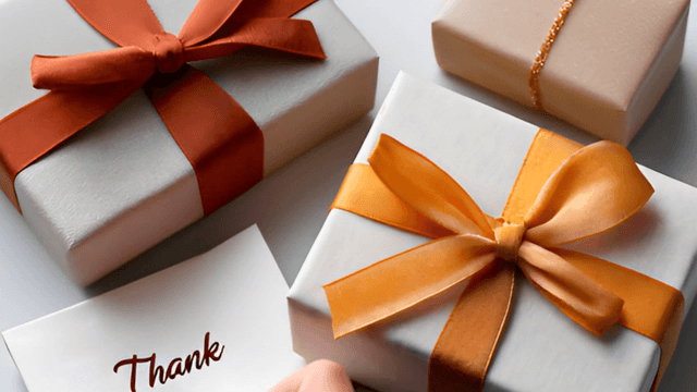 Gift boxes with ribbons and a thank you card