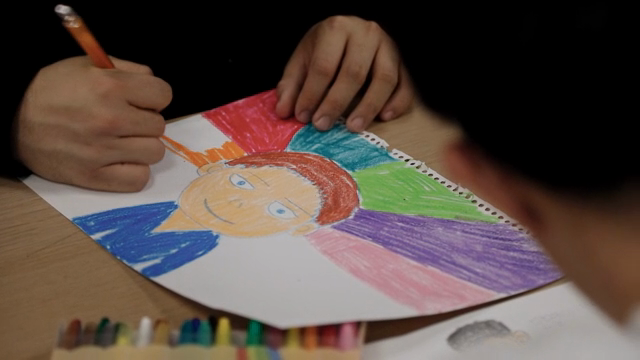 A person drawing a colorful portrait