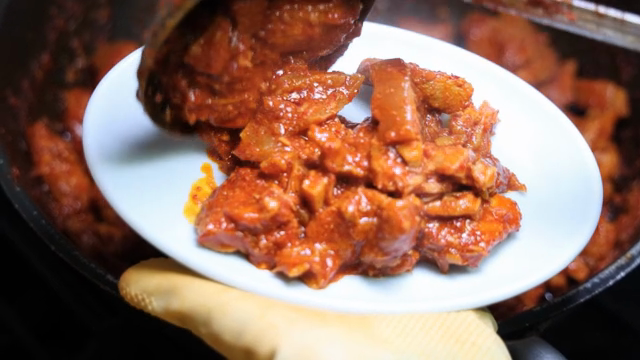 Spicy stir-fried pork being served on a plate