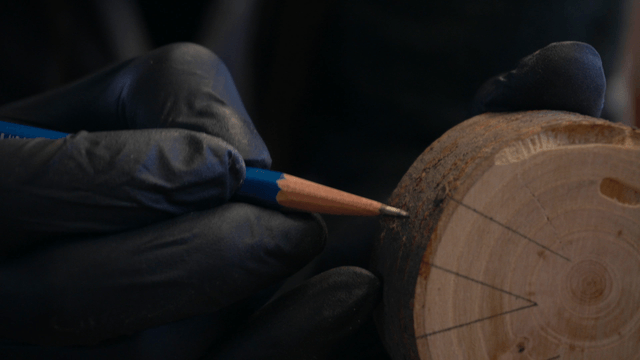 Woodcraft artisan drawing lines on wooden piece