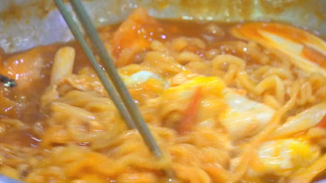Mixing the ramyeon and eggs in a pot