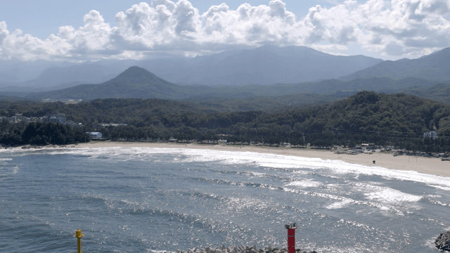 Serene beach with mountains in the background