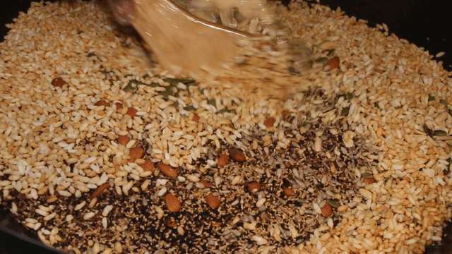 Mixing honey and nuts in a pan