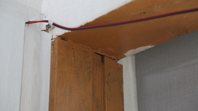 Corner of a room with exposed wiring