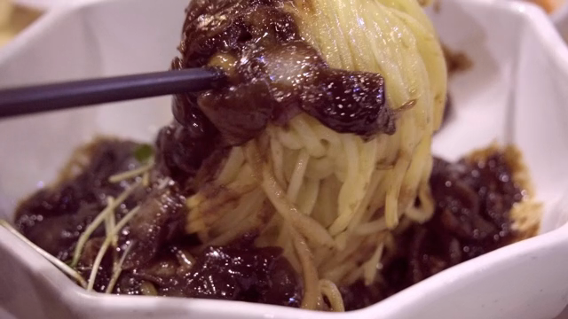 Noodles in Black Bean Sauce being mixed in a bowl