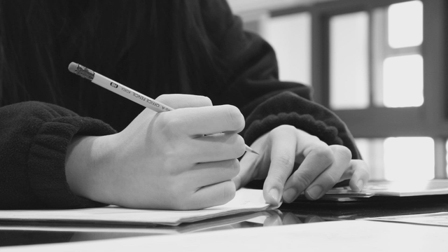 Person writing notes with focus