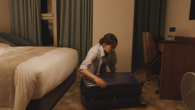 Woman organizing her suitcase in a hotel room