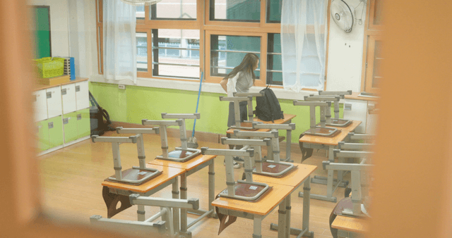 Student preparing to leave school in an empty classroom