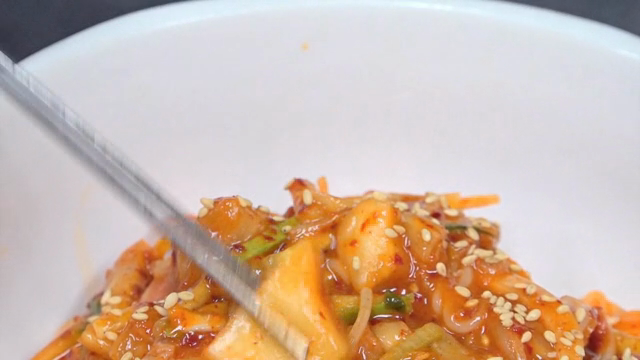 A piece of kimchi in spicy noodles