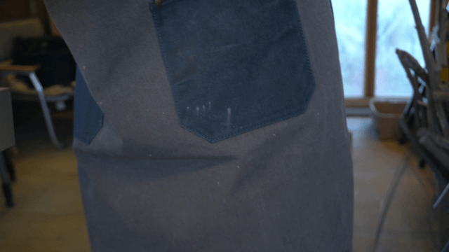 Artisan holding a wooden piece in workshop