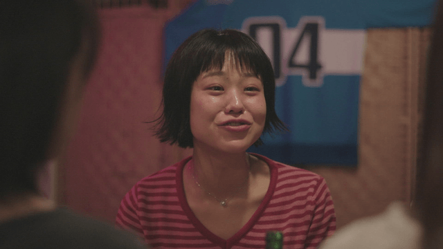 Woman in a striped shirt chatting indoors