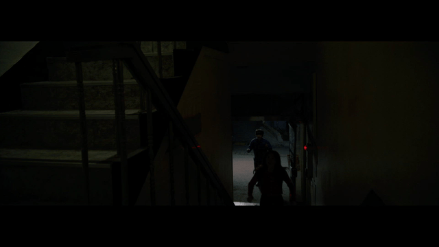 People entering a dimly lit hallway