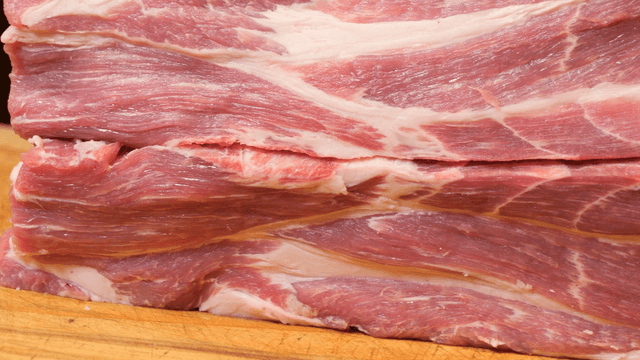 Raw pork meat stacked on a wooden board