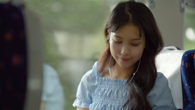 기차에서 음악을 듣는 젊은 여성