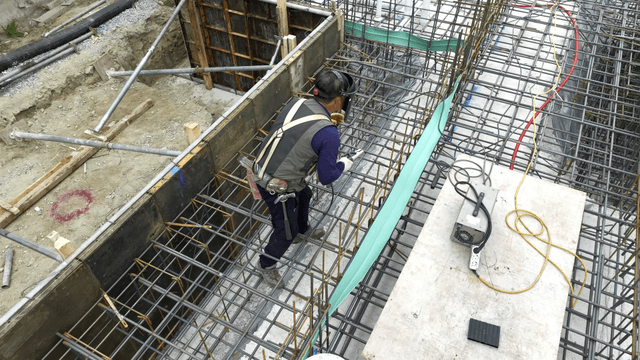 Construction worker welding steel bars