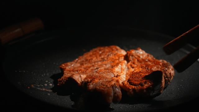 Steak being cooked on a pan