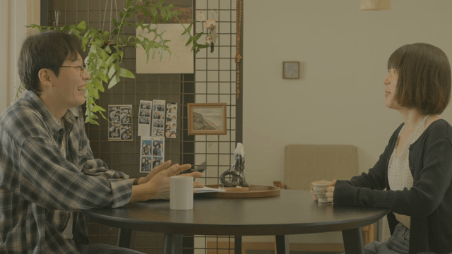 Two people talking at home dining table