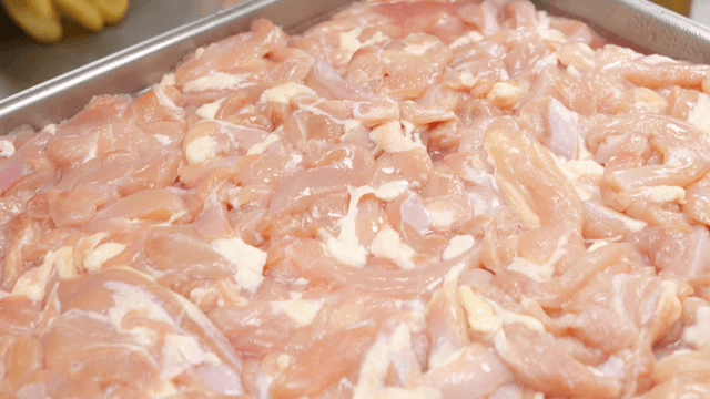 Raw chicken pieces in a metal tray