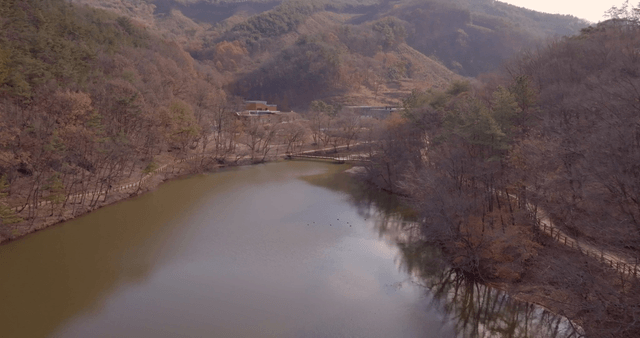 A serene landscape with a lake and buildings