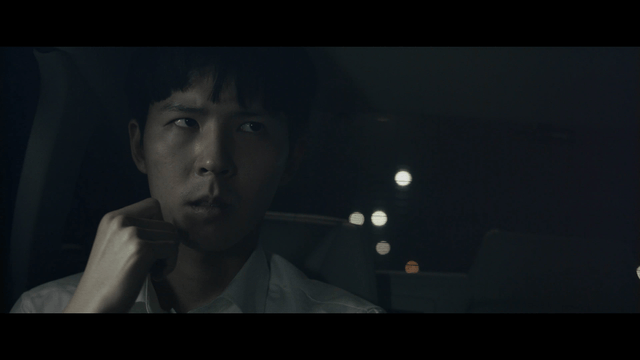 Student in a car at night looking thoughtful