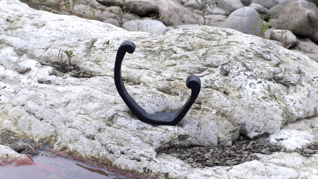 Black wooden sculpture on rocky terrain