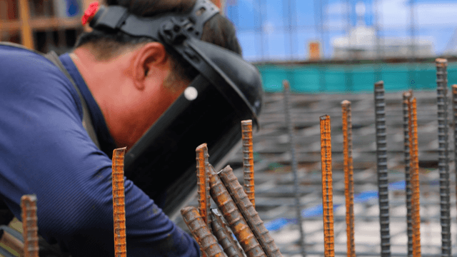 Construction worker welding metal rods
