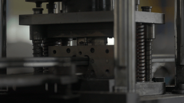 작동 중인 금속 프레스 기계의 근접 촬영