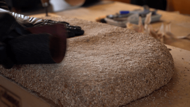 Artisan carefully sanding a cork sculpture