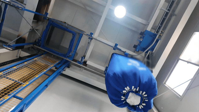 Laundry factory machine moving stacks of white fabric