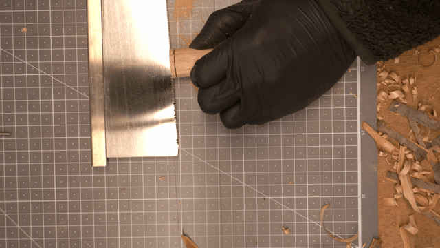 Hand cutting wood with a saw on a workbench