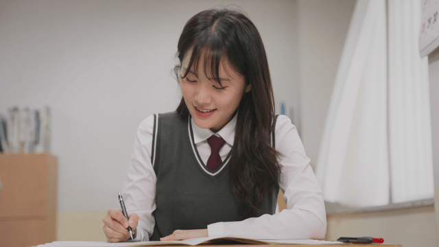 시험 문제를 풀며 웃는 학생