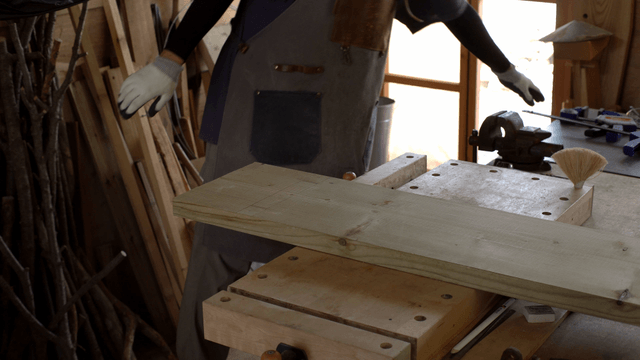 Person preparing wood in a workshop