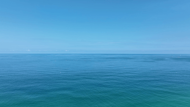 A beach with surfers and clear blue sea