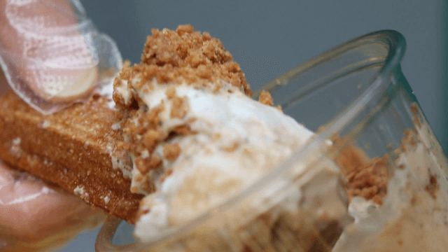 Churros being dipped in dessert cups