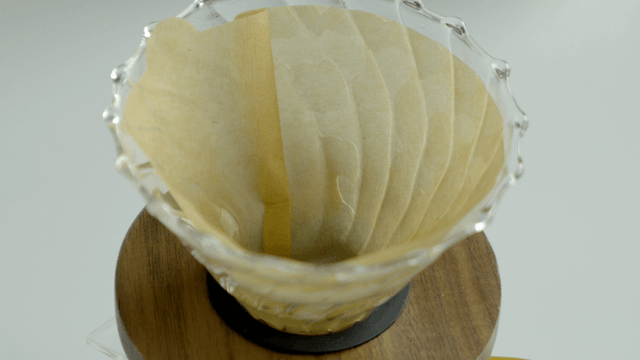 Ground coffee being poured into a coffee dripper filter