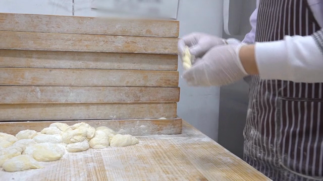 Baker shaping dough in a kitchen