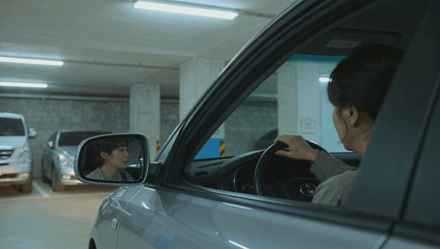 Woman driving a car out of the parking lot