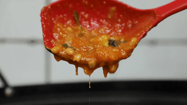 Snail soybean paste sauce dripping from a ladle