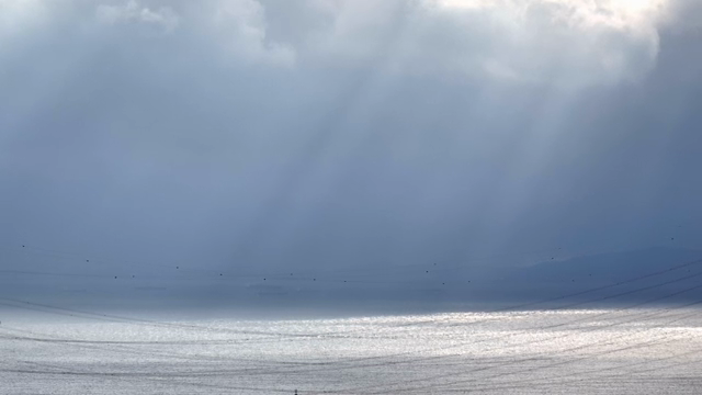 Sunlight streaming through clouds over the sea
