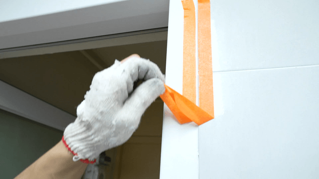 Masking tape removed after applying sealant on bathroom wall