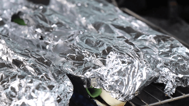 Foil-wrapped food on a grill