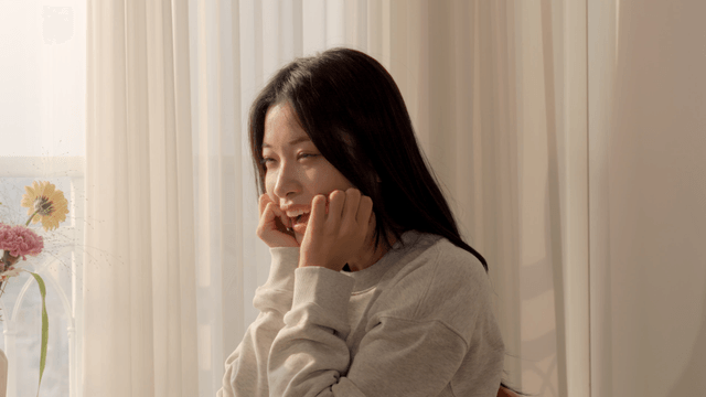 Smiling woman by sunlit window